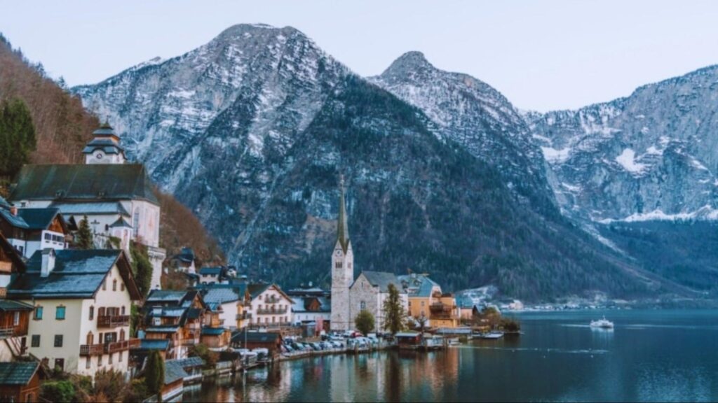 Aerial view of Hallstatt, Austria, highlighting the charming village nestled between a lake and steep mountains.