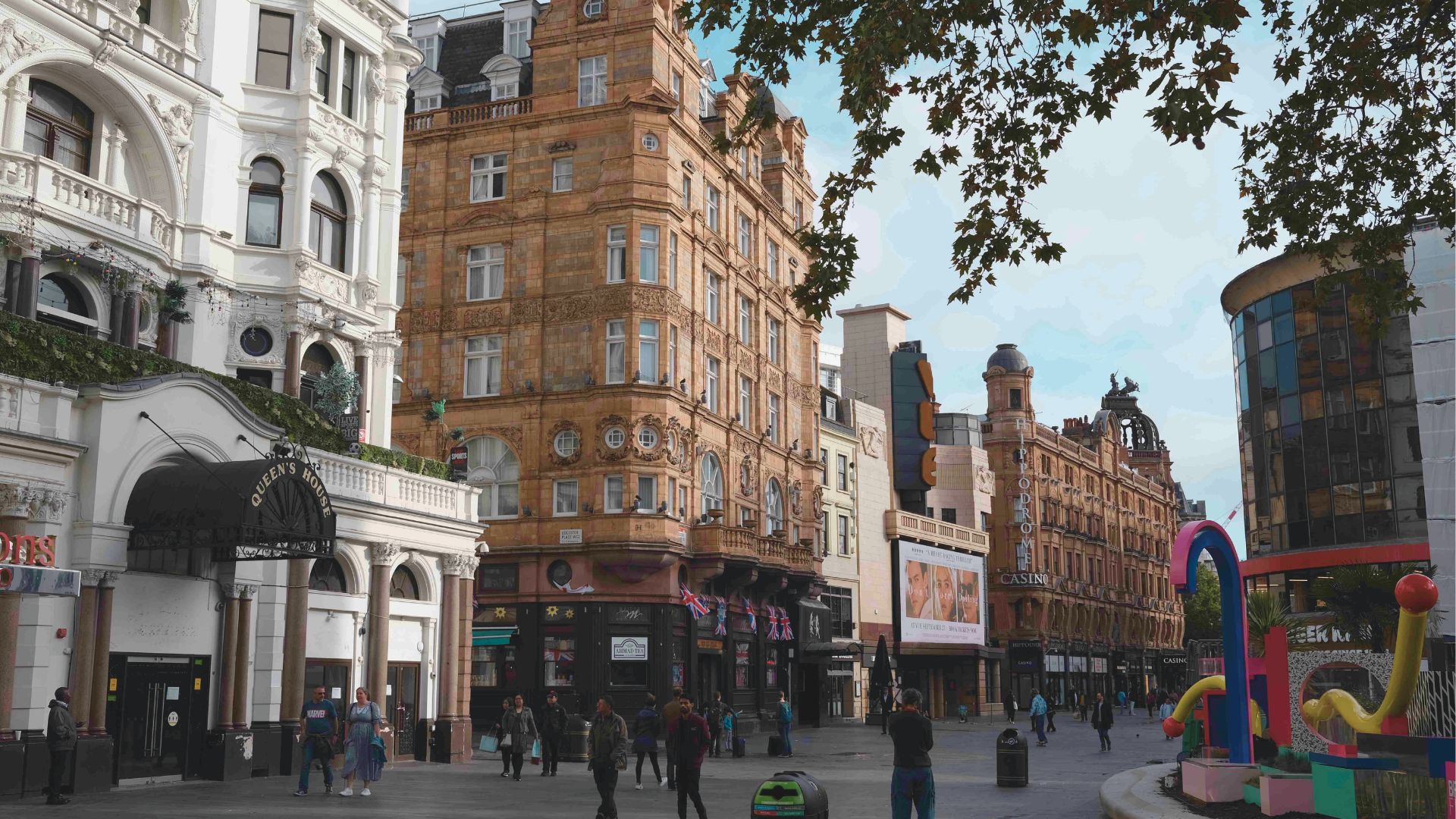 A bustling street scene featuring people walking and a prominent building in the background.