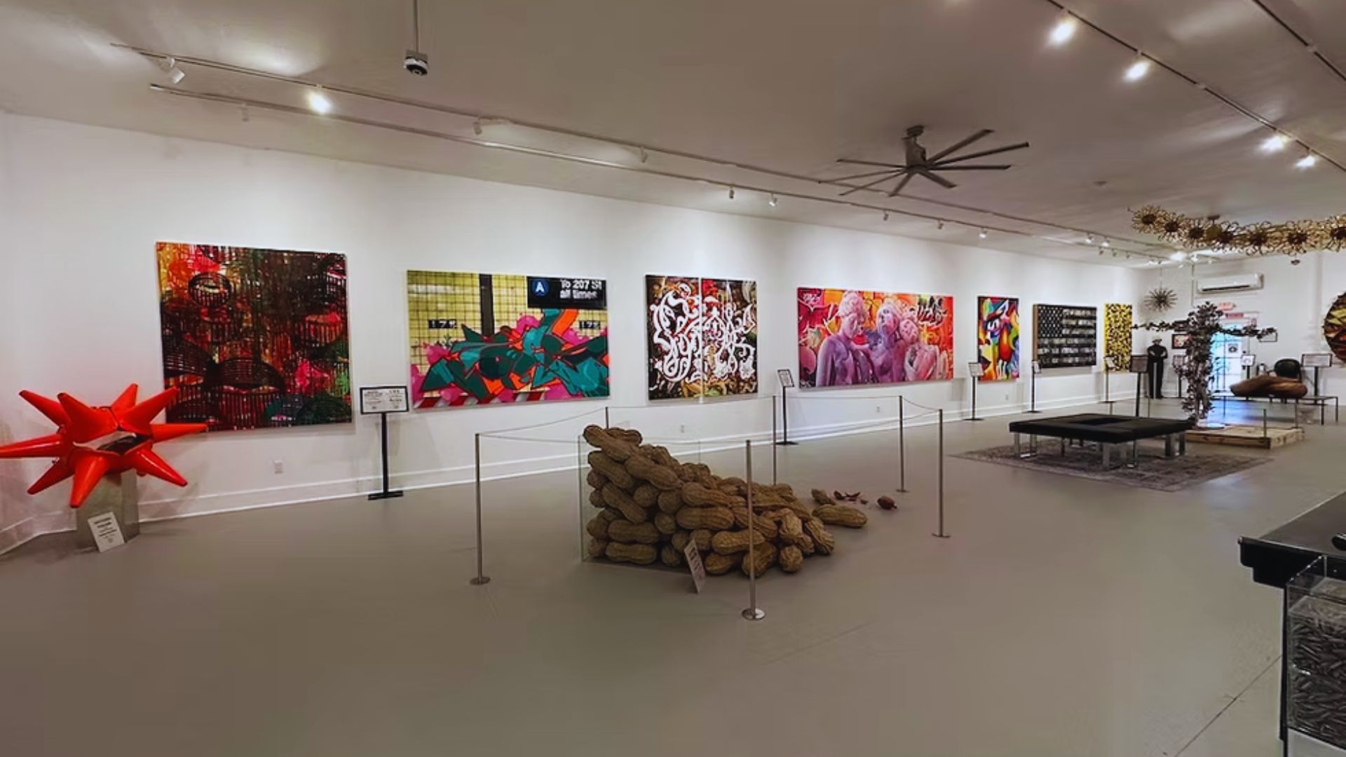 A spacious room featuring vibrant paintings adorning the walls, creating a lively and artistic atmosphere.