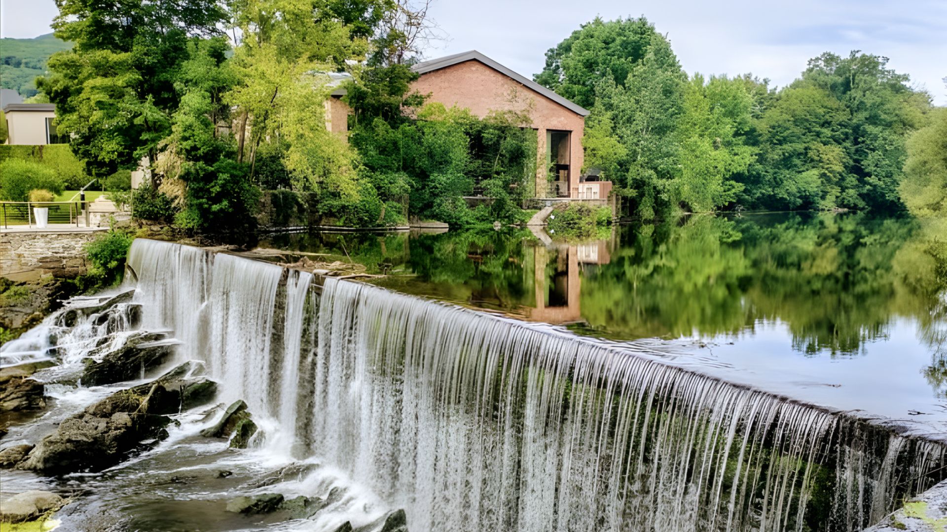 A waterfall cascades into a river, creating a stunning natural feature in the landscape.
