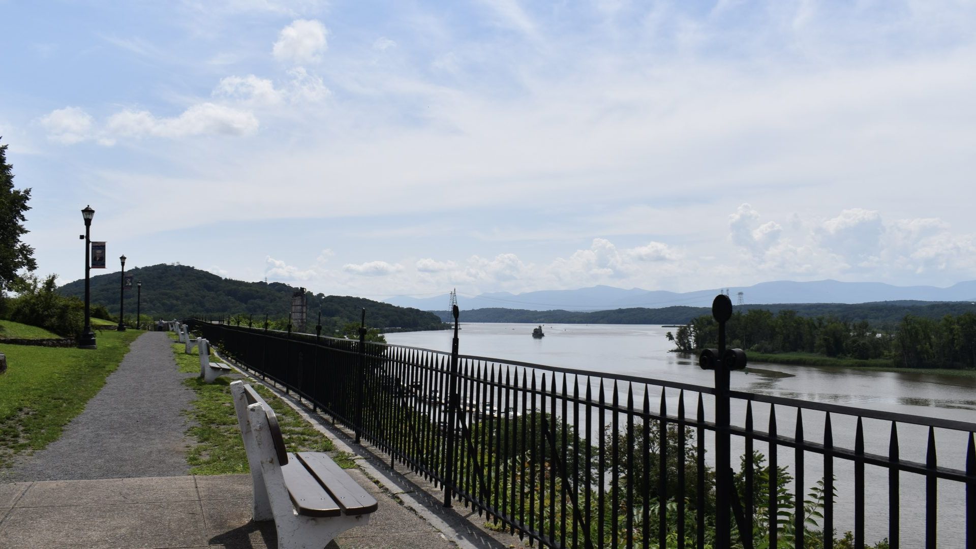 A wooden bench positioned beside a tranquil body of water, offering a scenic view of the landscape.