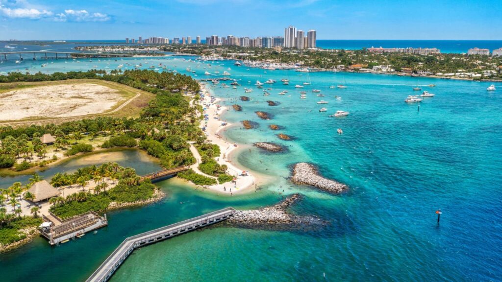 Aerial view of Miami Beach, showcasing the coastline, vibrant buildings, and clear blue waters of Florida.