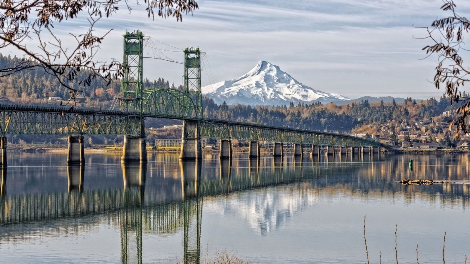 A bridge crosses a body of water, with a mountain rising majestically in the background.
