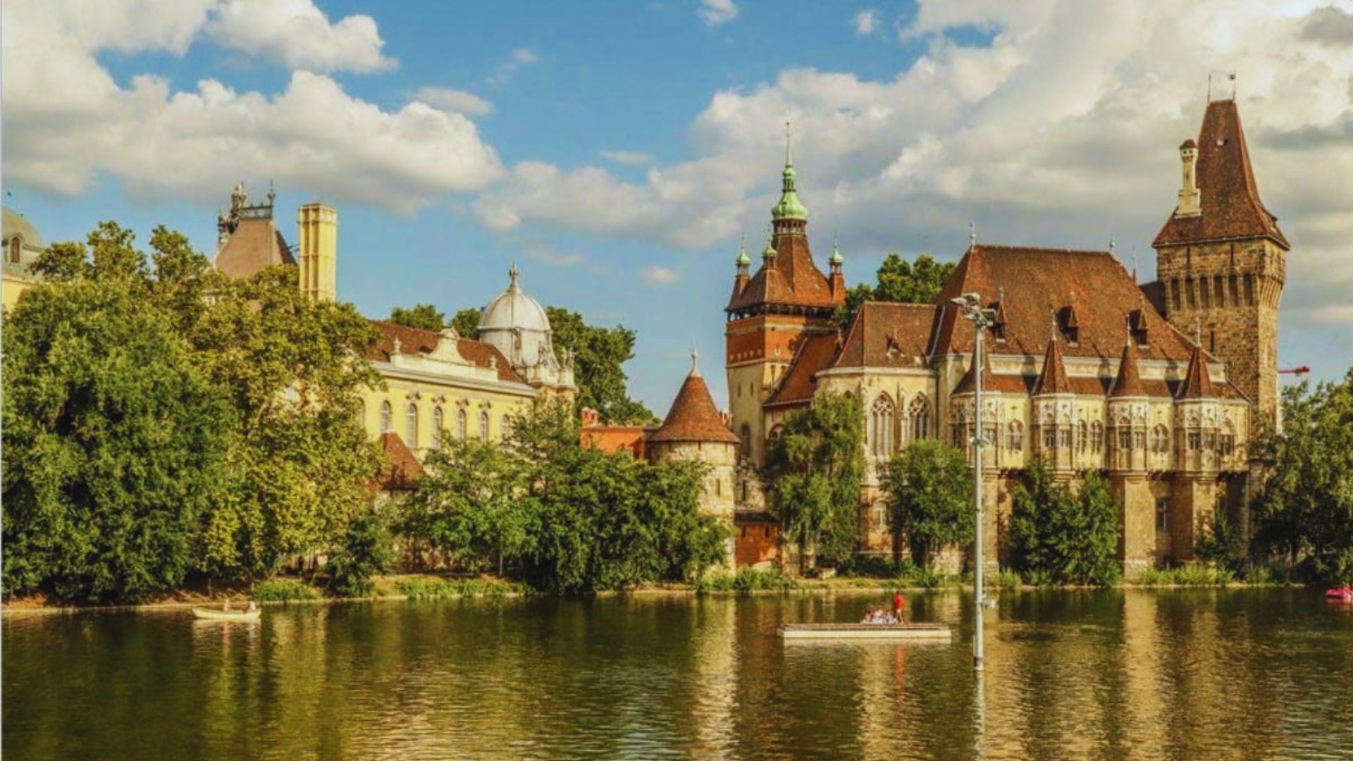 A stunning castle overlooks a serene lake, surrounded by lush greenery and reflecting the beauty of the landscape.