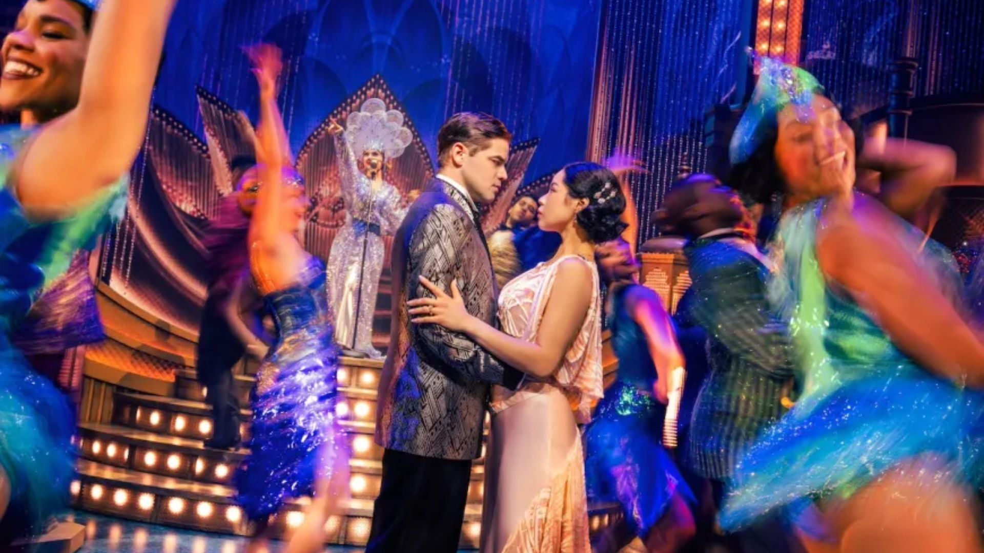 The cast of Broadway's "Broadway Baby" poses together, showcasing their vibrant costumes and joyful expressions.