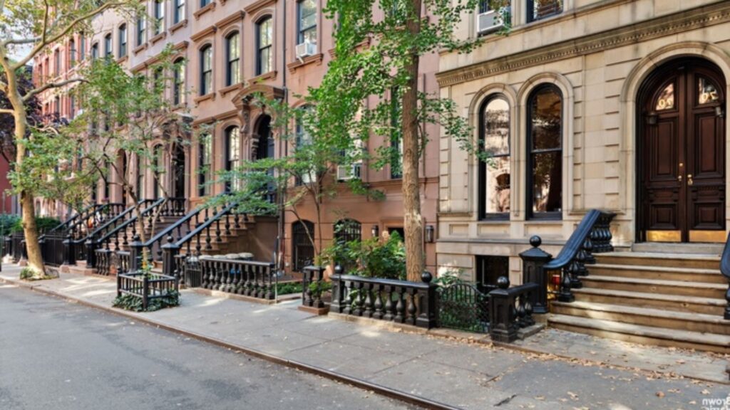 A row of brownstone buildings lining a bustling city street, showcasing urban architecture and vibrant city life.