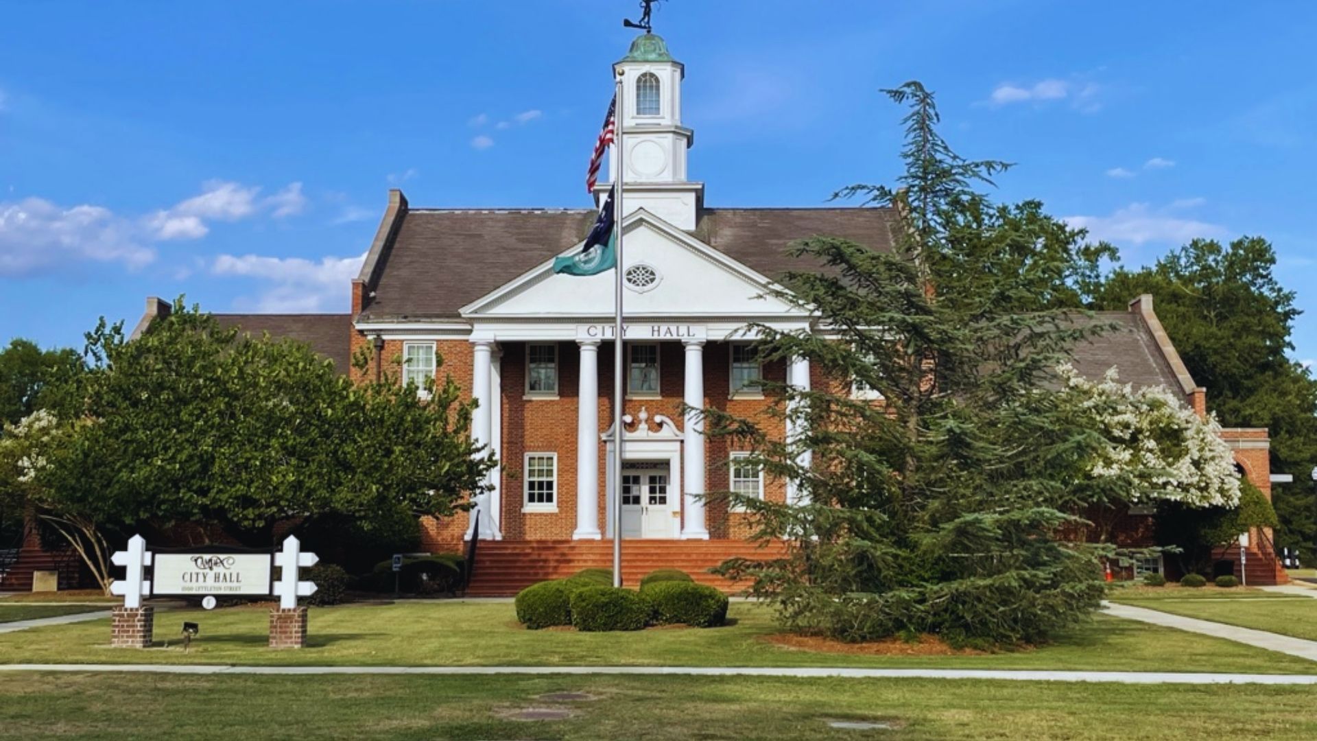 The historic courthouse in Alabama, showcasing classic architecture and surrounded by trees and a clear blue sky.
