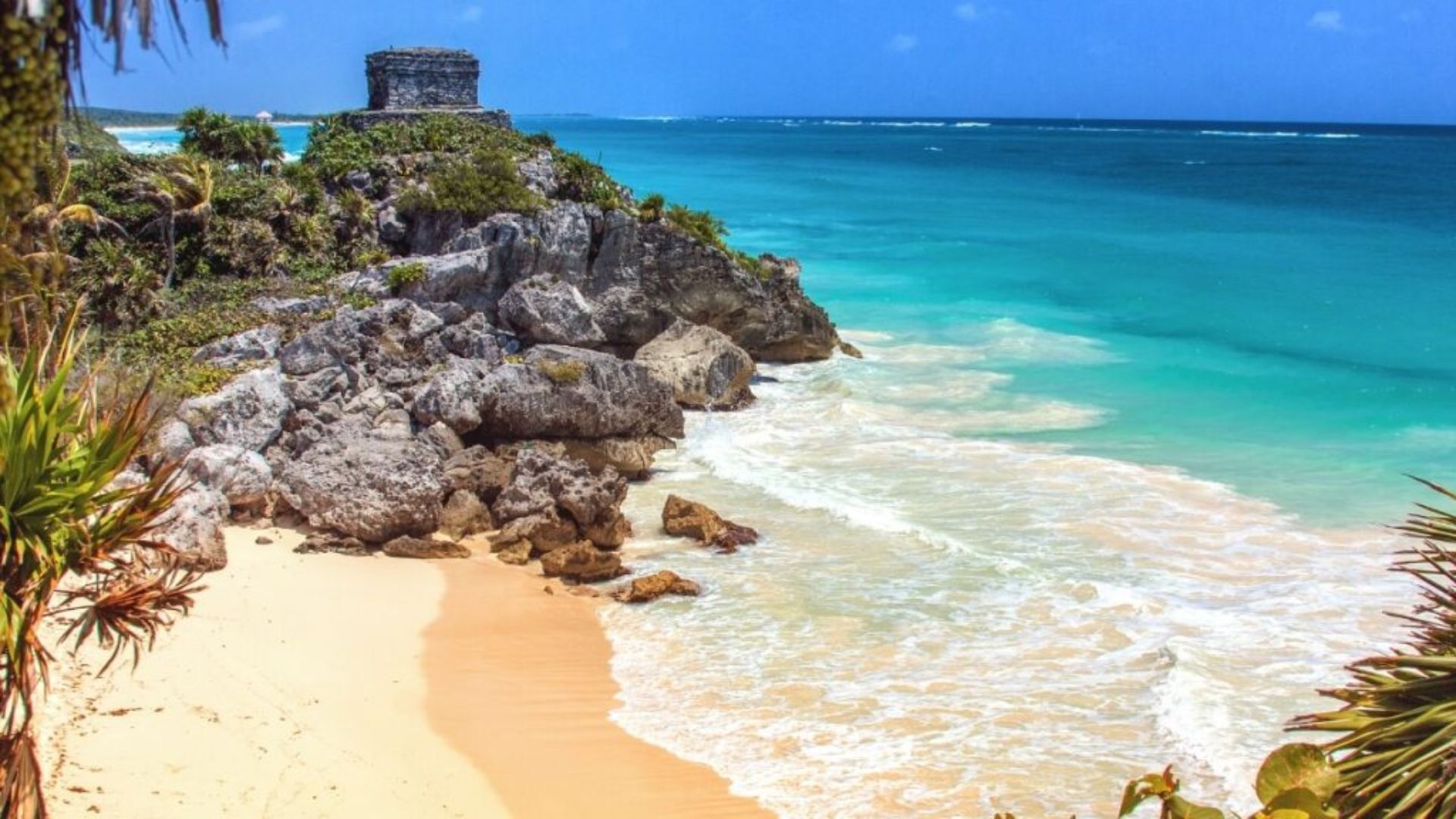 Scenic view of Tulum, Mexico, showcasing its beautiful beaches and ancient Mayan ruins against a clear blue sky.