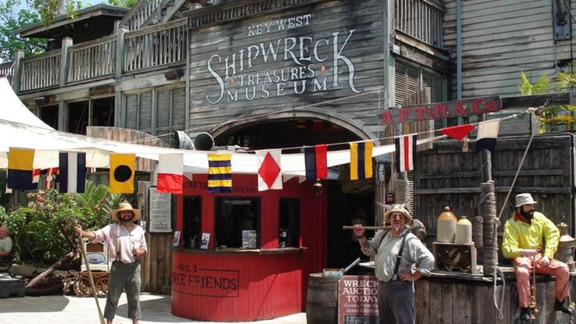 A group of people gathered outside a pirate-themed store, showcasing various pirate decorations and merchandise.