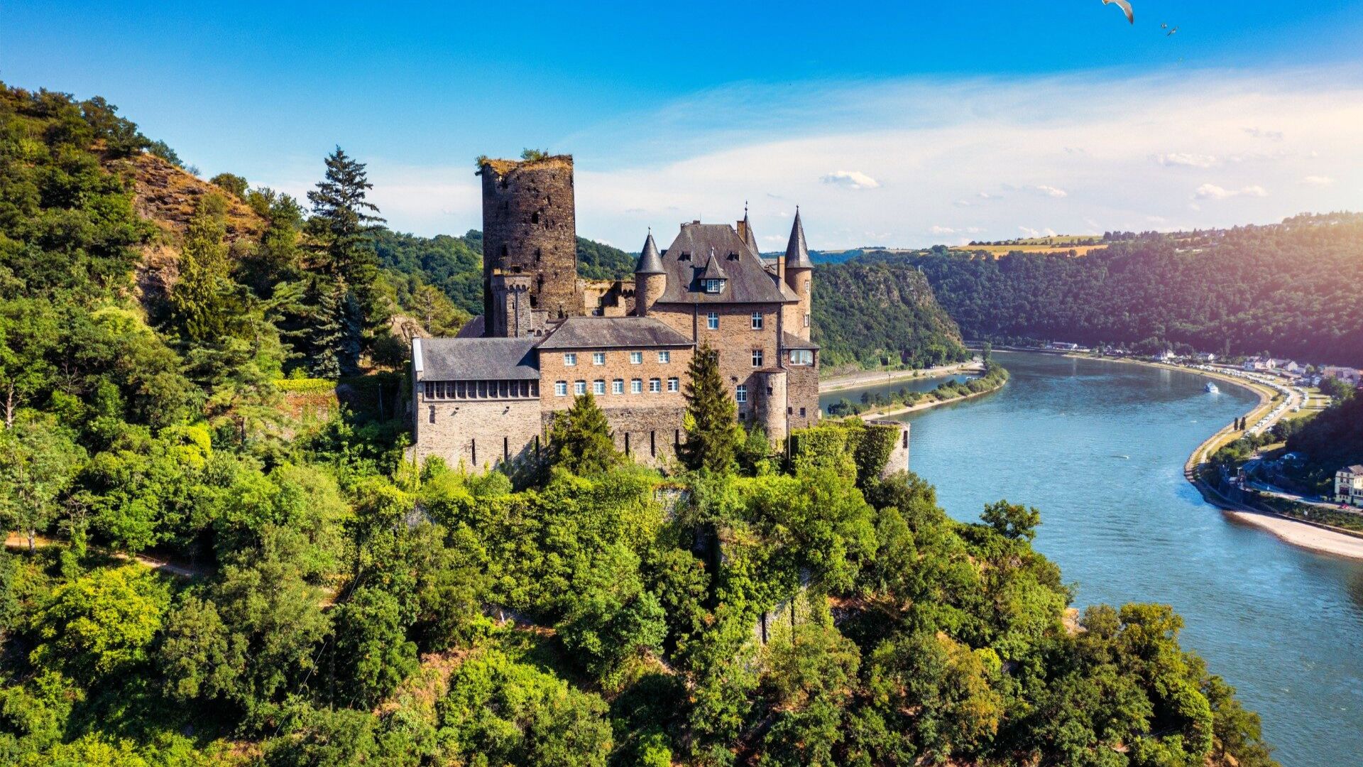 A picturesque castle beside a river in Germany, showcasing stunning architecture and scenic natural surroundings.