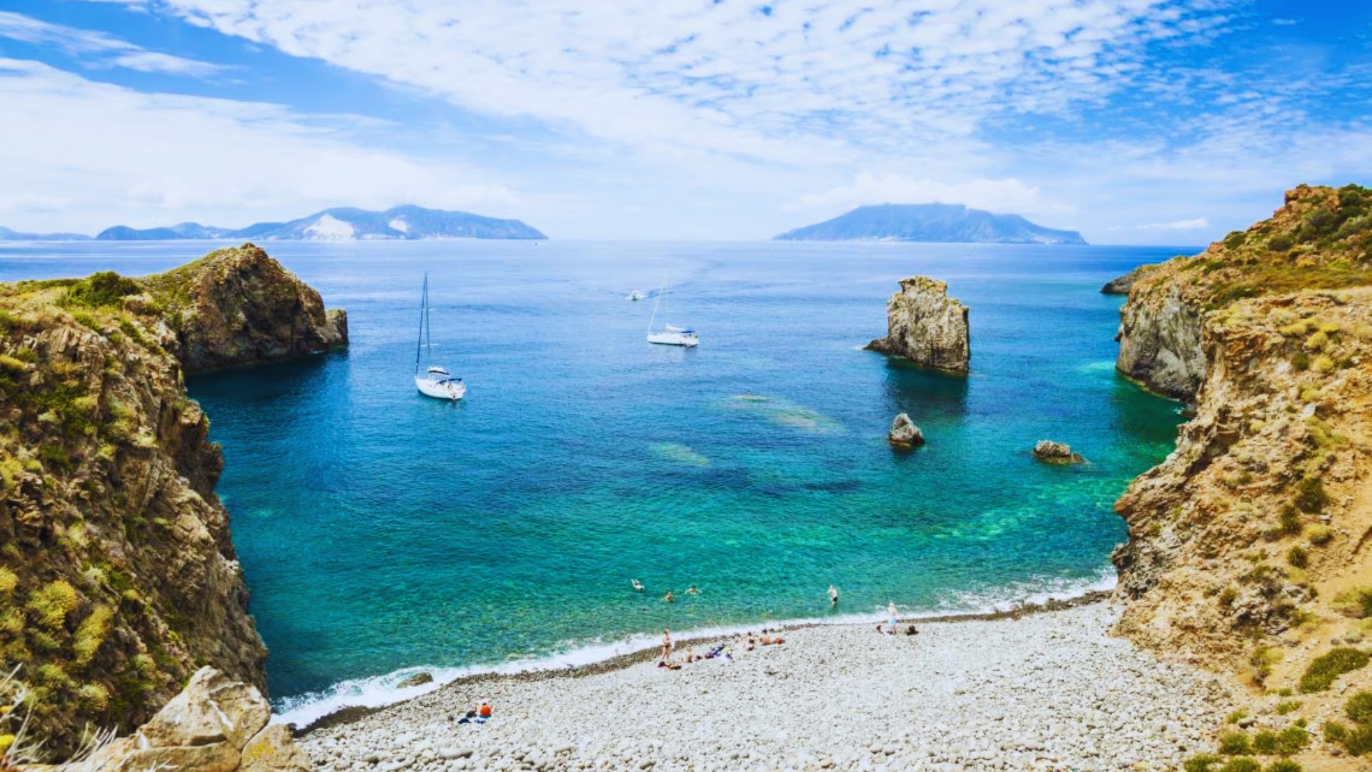 Scenic view of the beautiful Bay of Capri, Italy, showcasing turquoise waters and lush cliffs under a clear blue sky.
