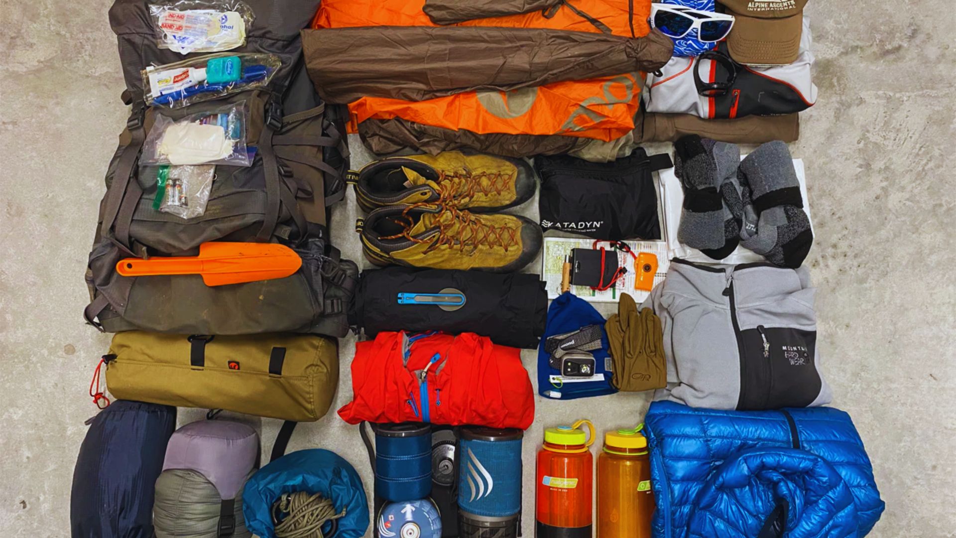 A large bag filled with a backpack, shoes, and various other items, showcasing a mix of travel essentials.
