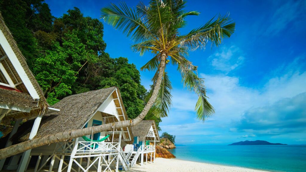 A tropical beach landscape showcasing thatched huts and tall palm trees, creating a peaceful and idyllic atmosphere.