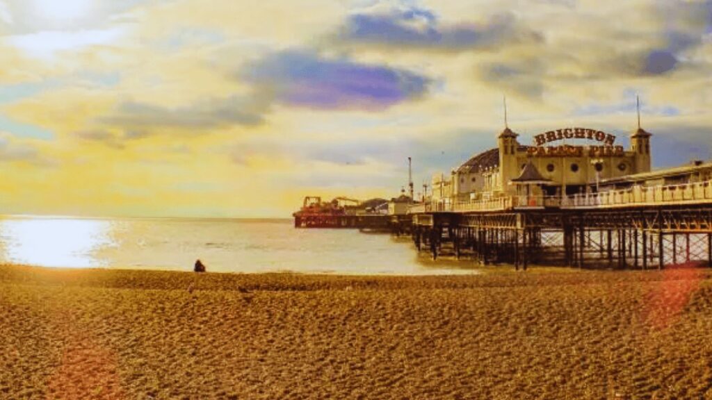 Brighton Pier silhouetted against a vibrant sunset, with colorful skies reflecting on the calm sea.