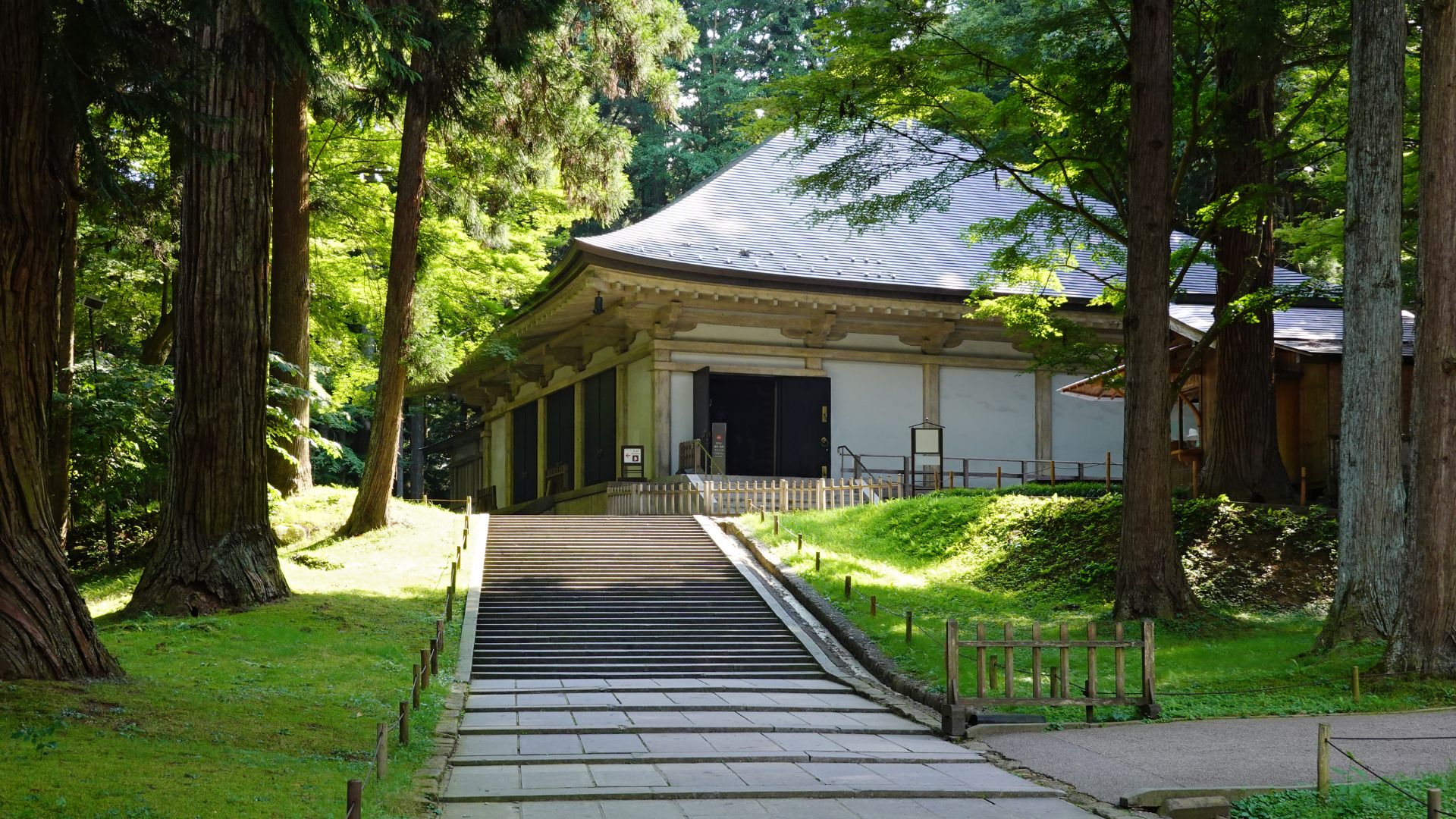 A winding path through dense woods leading to a serene temple nestled among the trees.