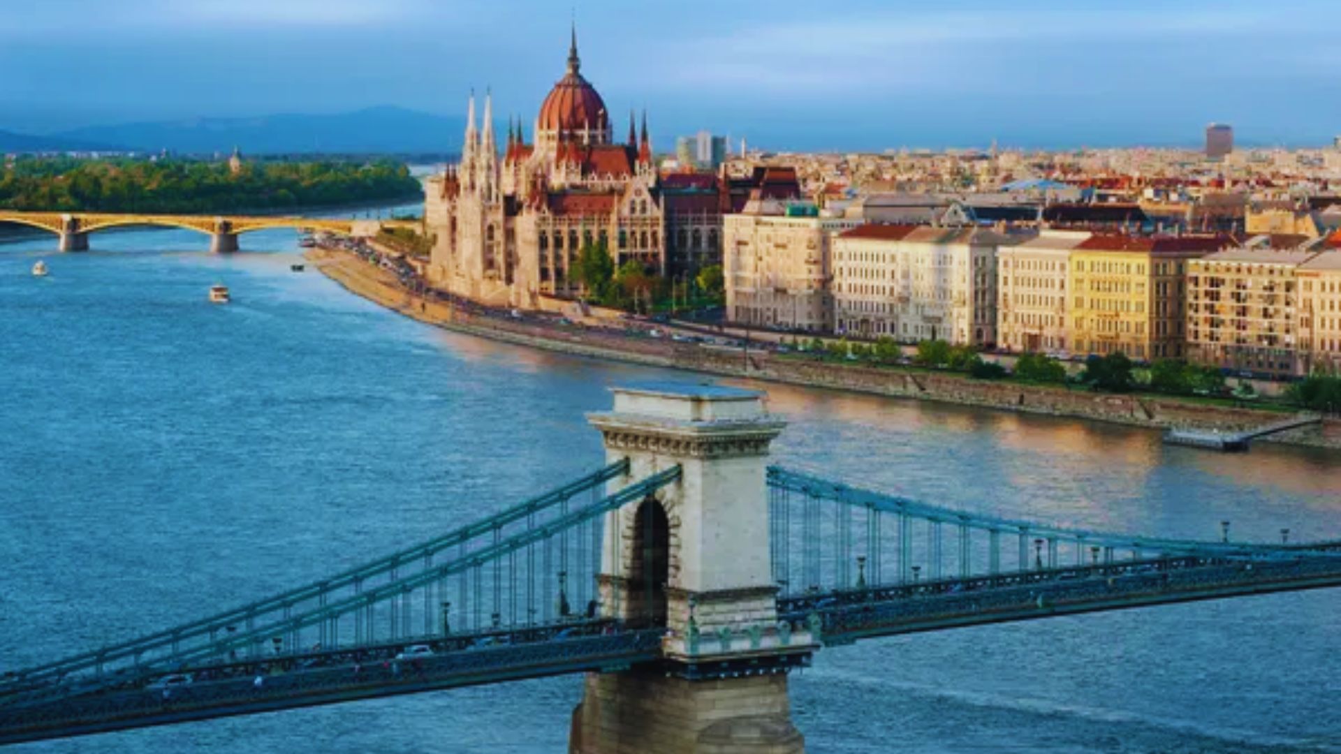 A panoramic view of Budapest, Hungary, showcasing its iconic architecture and the Danube River under a clear sky.