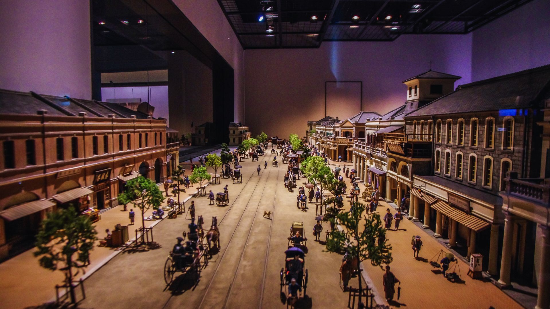 A detailed model of a city street featuring buildings and miniature people interacting in a vibrant urban setting.