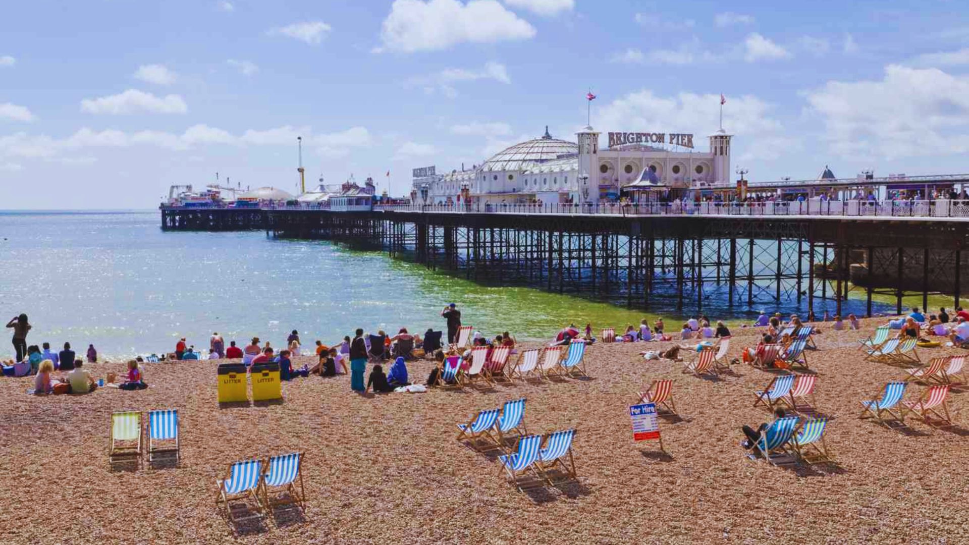 Brighton Beach in England, featuring sandy shores, colorful beach huts, and a vibrant seaside atmosphere.