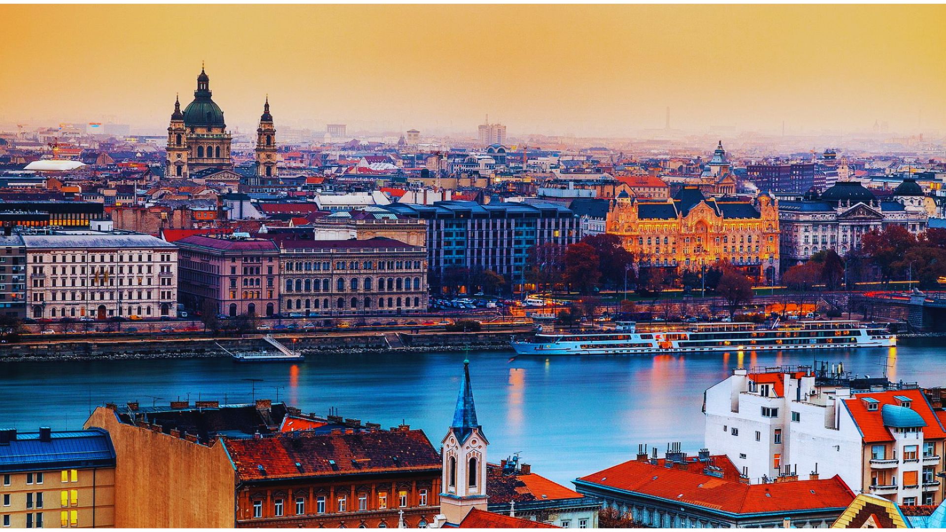A panoramic view of Budapest, Hungary, showcasing the Danube River flowing through the cityscape.