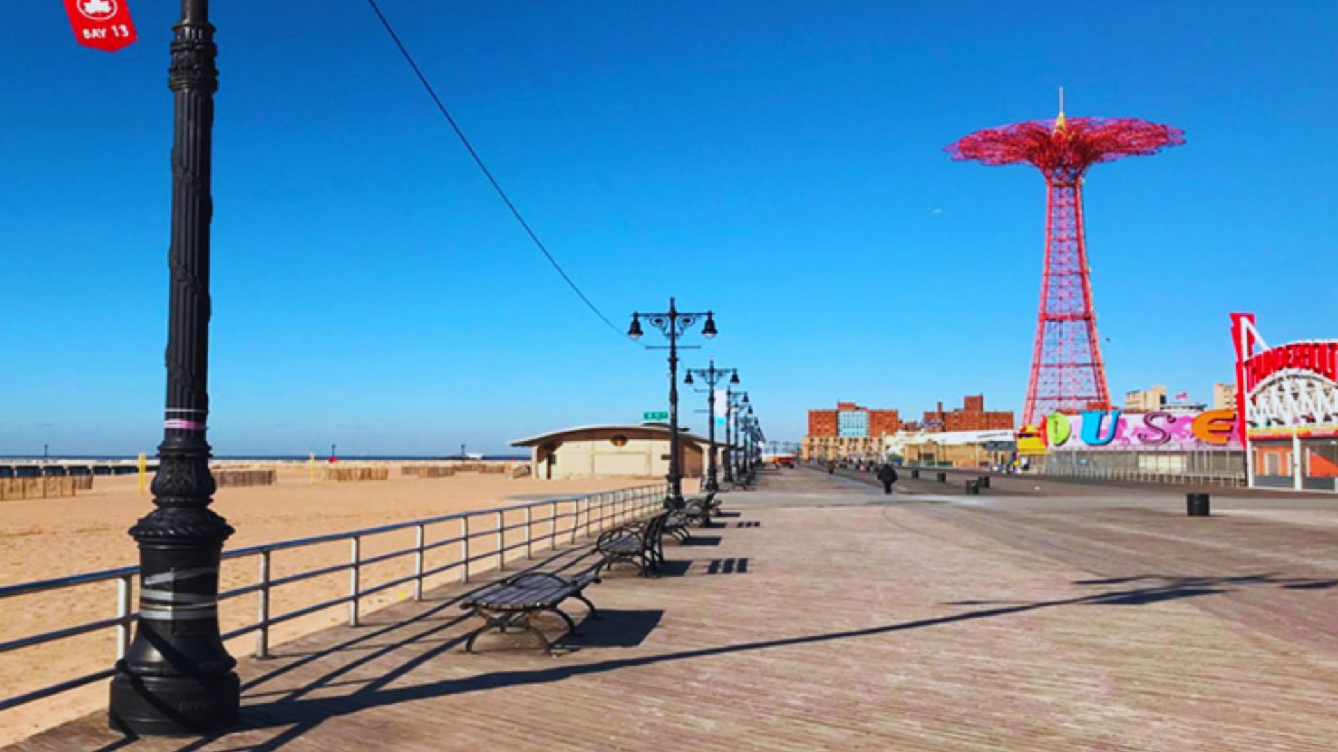 A scenic boardwalk featuring benches and a colorful Ferris wheel in the background, inviting visitors to relax and enjoy.
