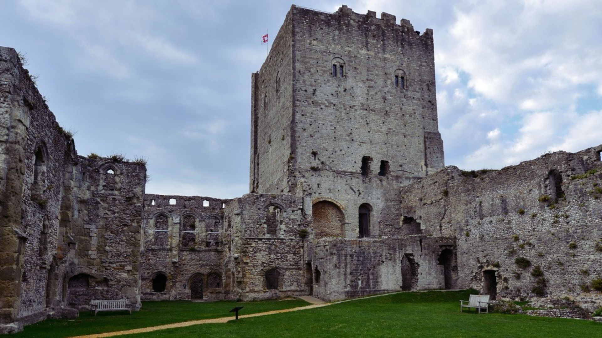 A large castle stands majestically with a lush green lawn surrounding its base.