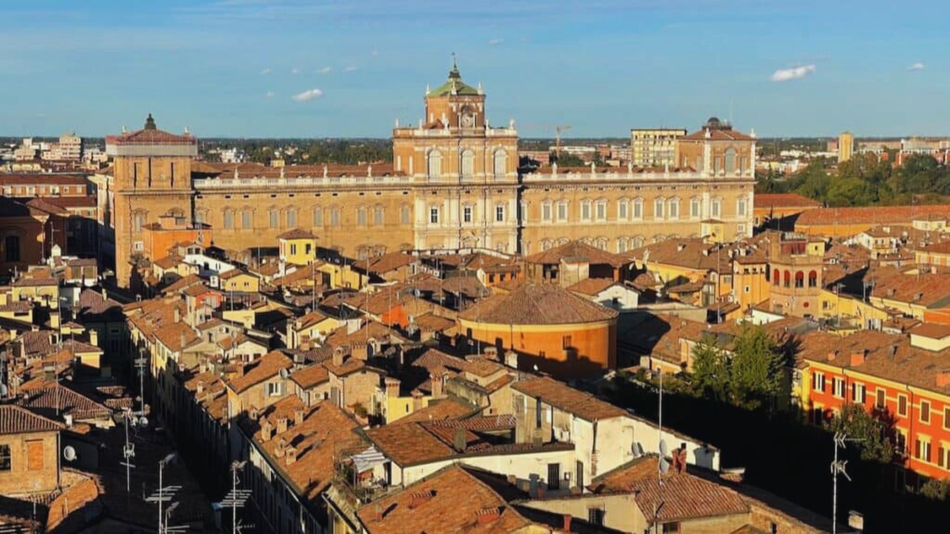 A panoramic view of Siena, Italy, showcasing its historic architecture and rolling hills under a clear blue sky.