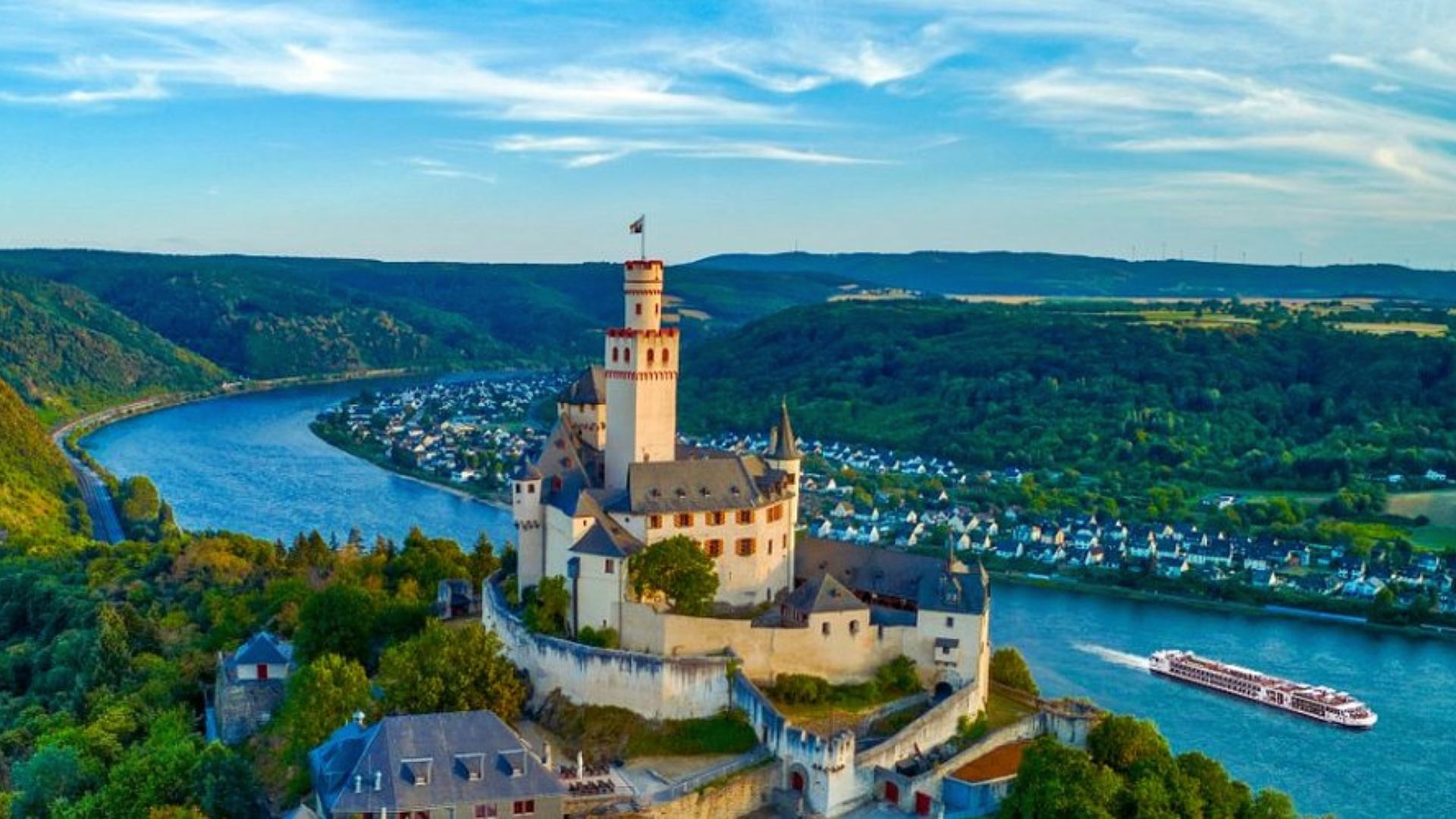 Scenic view of the Rhine River cruise, showcasing lush vineyards and historic castles along the riverbanks.