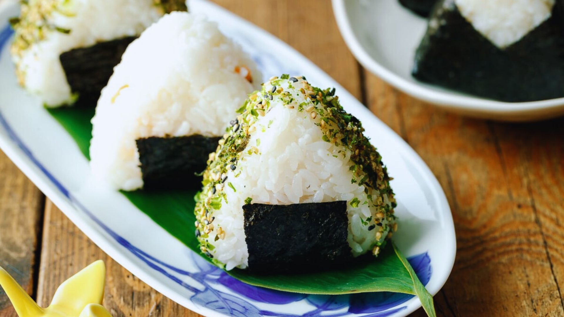 A plate of rice topped with black sesame seeds, showcasing a simple yet elegant dish.
