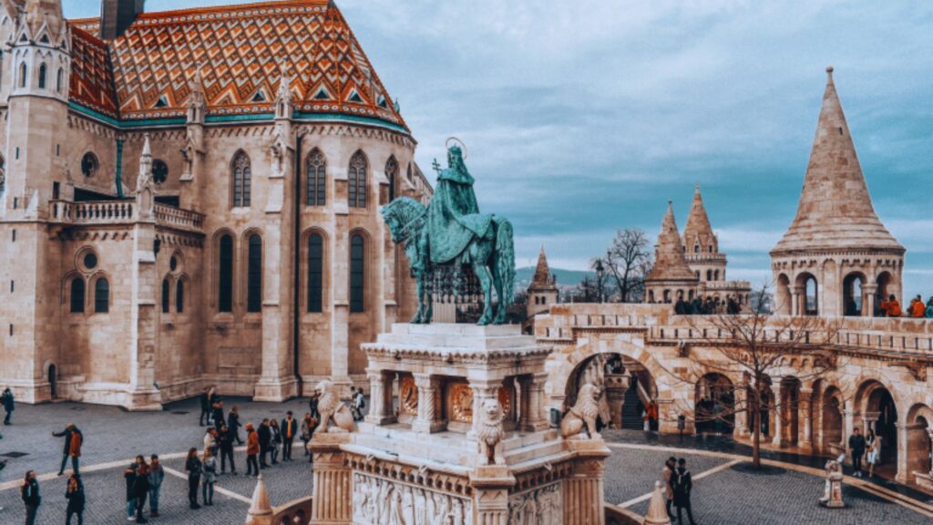 Budapest Castle with the Statue of Liberty in the foreground, showcasing a blend of historical architecture and symbolism.