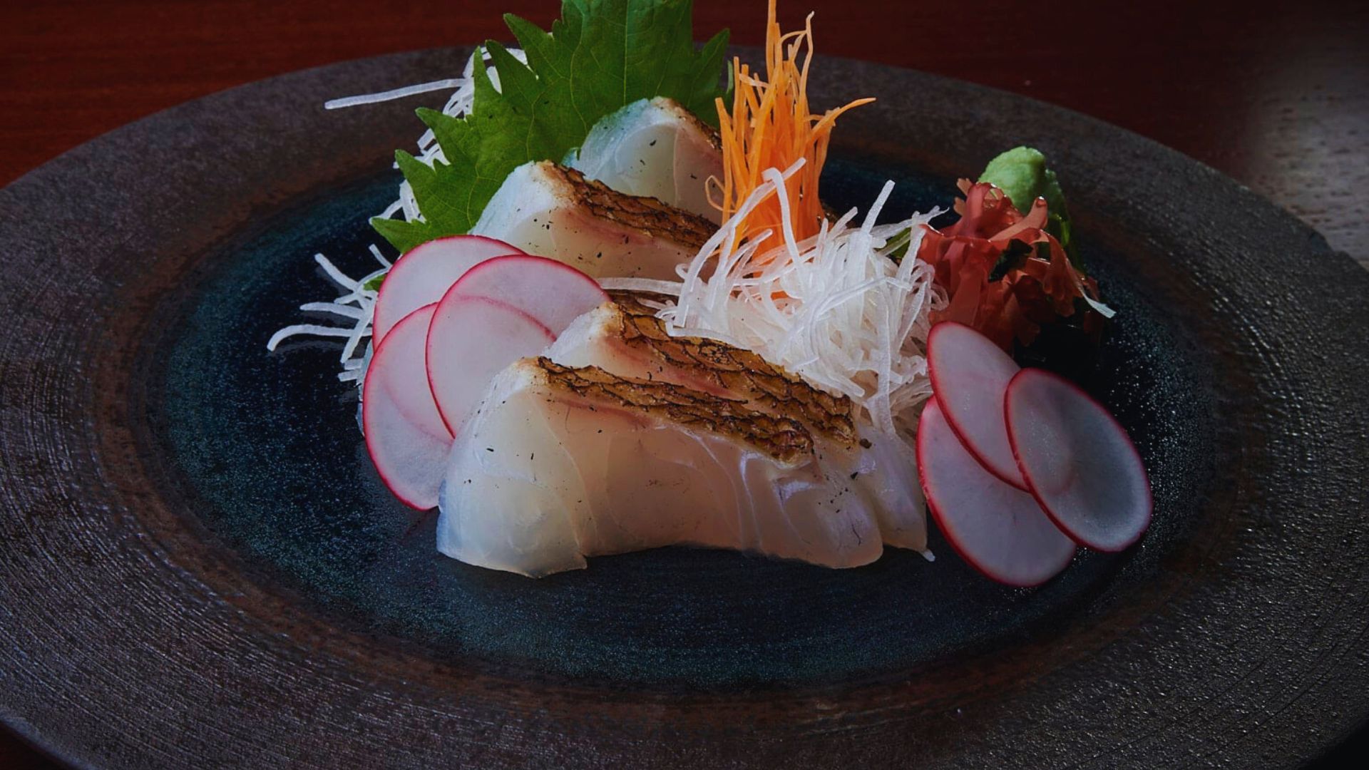 A colorful plate displaying various sushi pieces alongside vibrant vegetables.