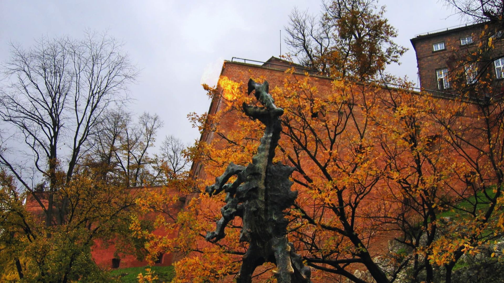 A statue of a horse stands prominently in front of a historic building, showcasing intricate details and craftsmanship.
