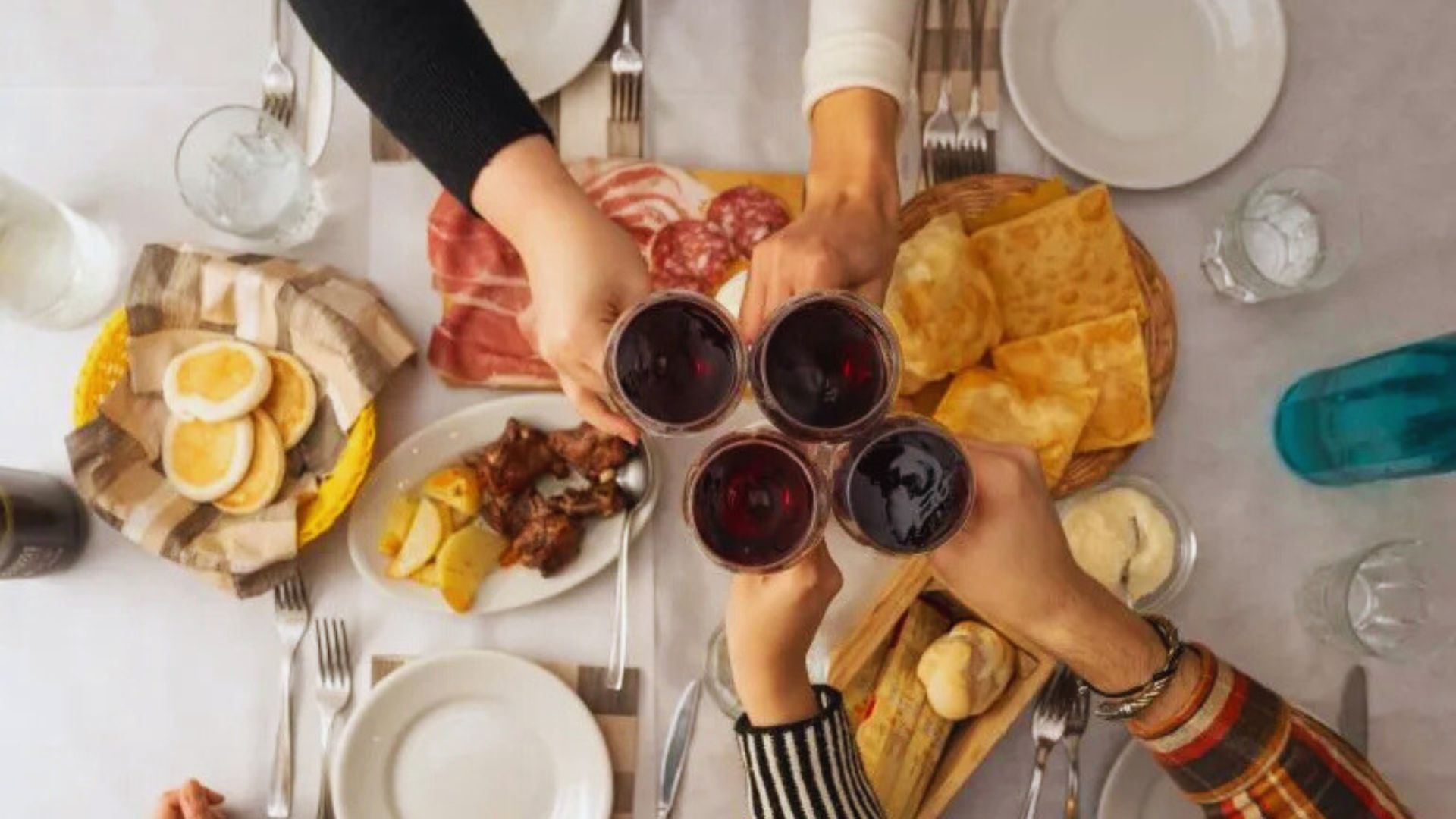 A group of diverse people joyfully toasting with wine glasses at a celebration.