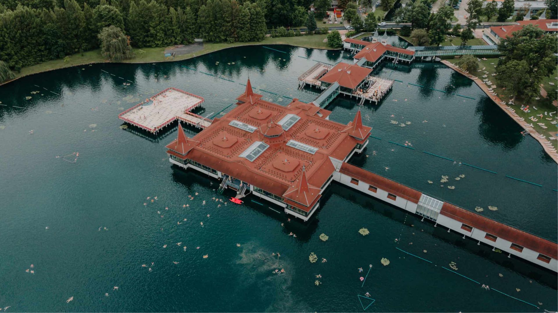 Aerial view of a serene lake featuring a castle situated on an island in the center.