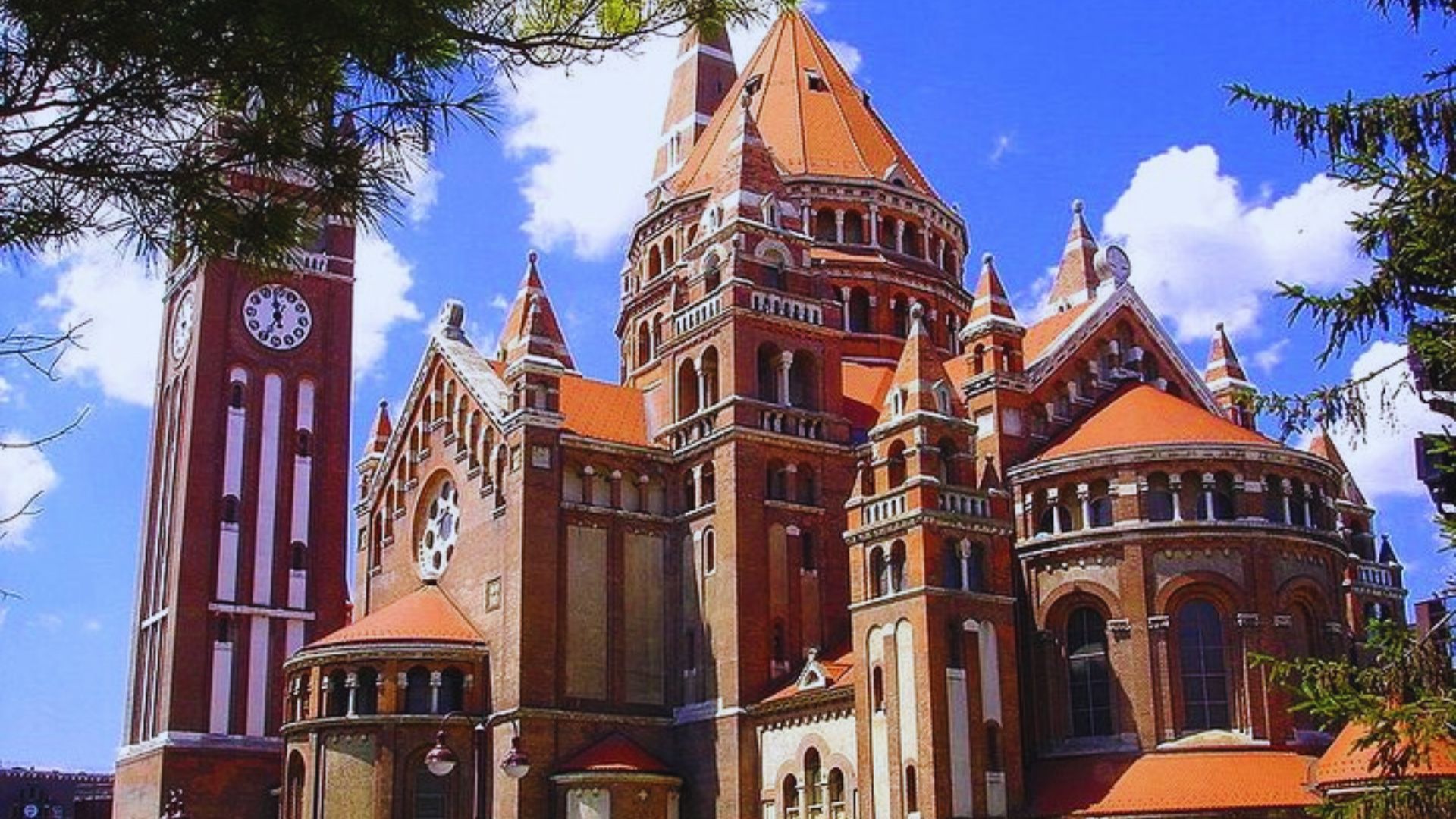 A large church featuring a prominent clock tower in front, showcasing its architectural grandeur.