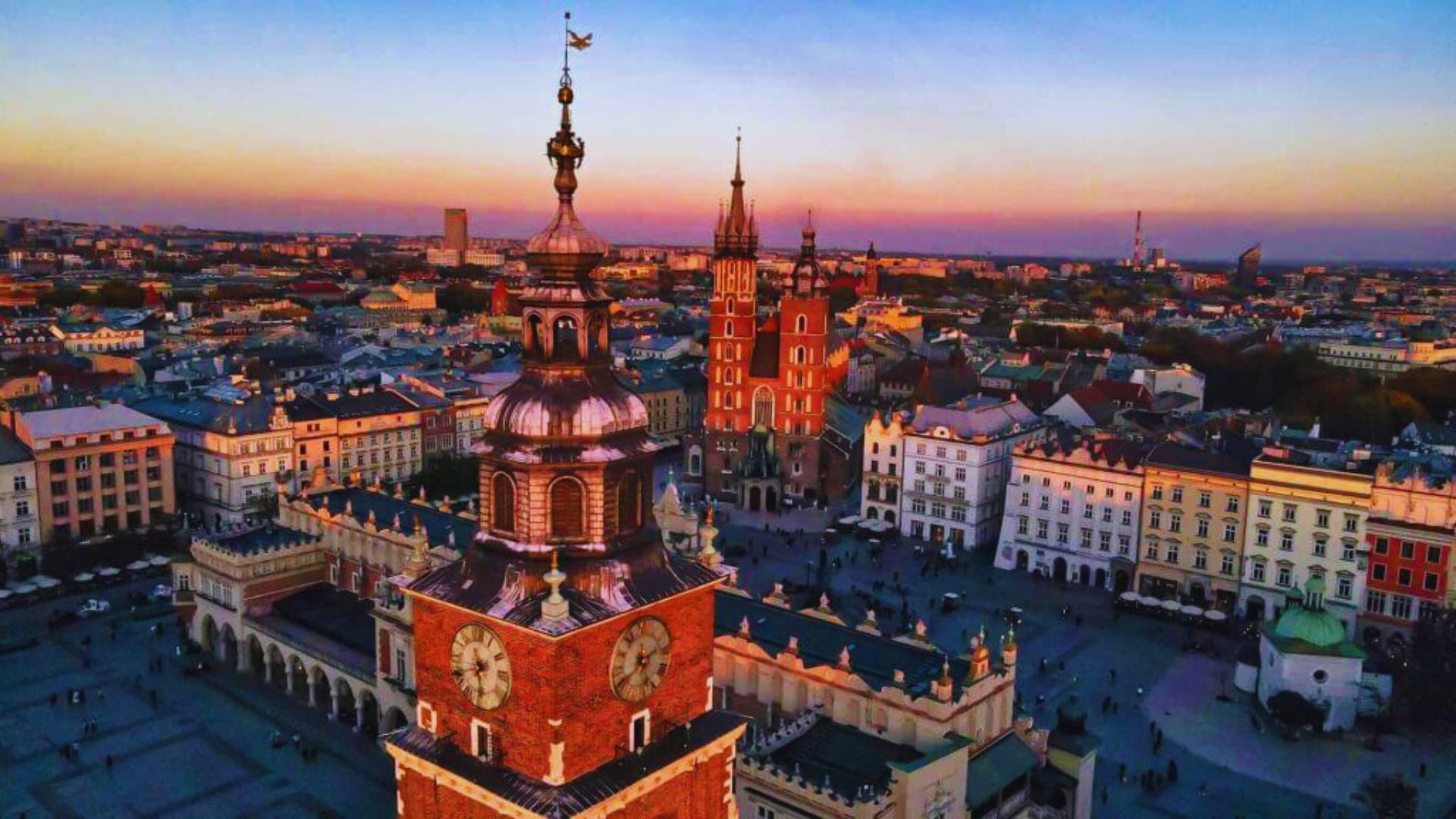 A panoramic view from the old town hall tower in Krakow, showcasing historic buildings and bustling city life below.