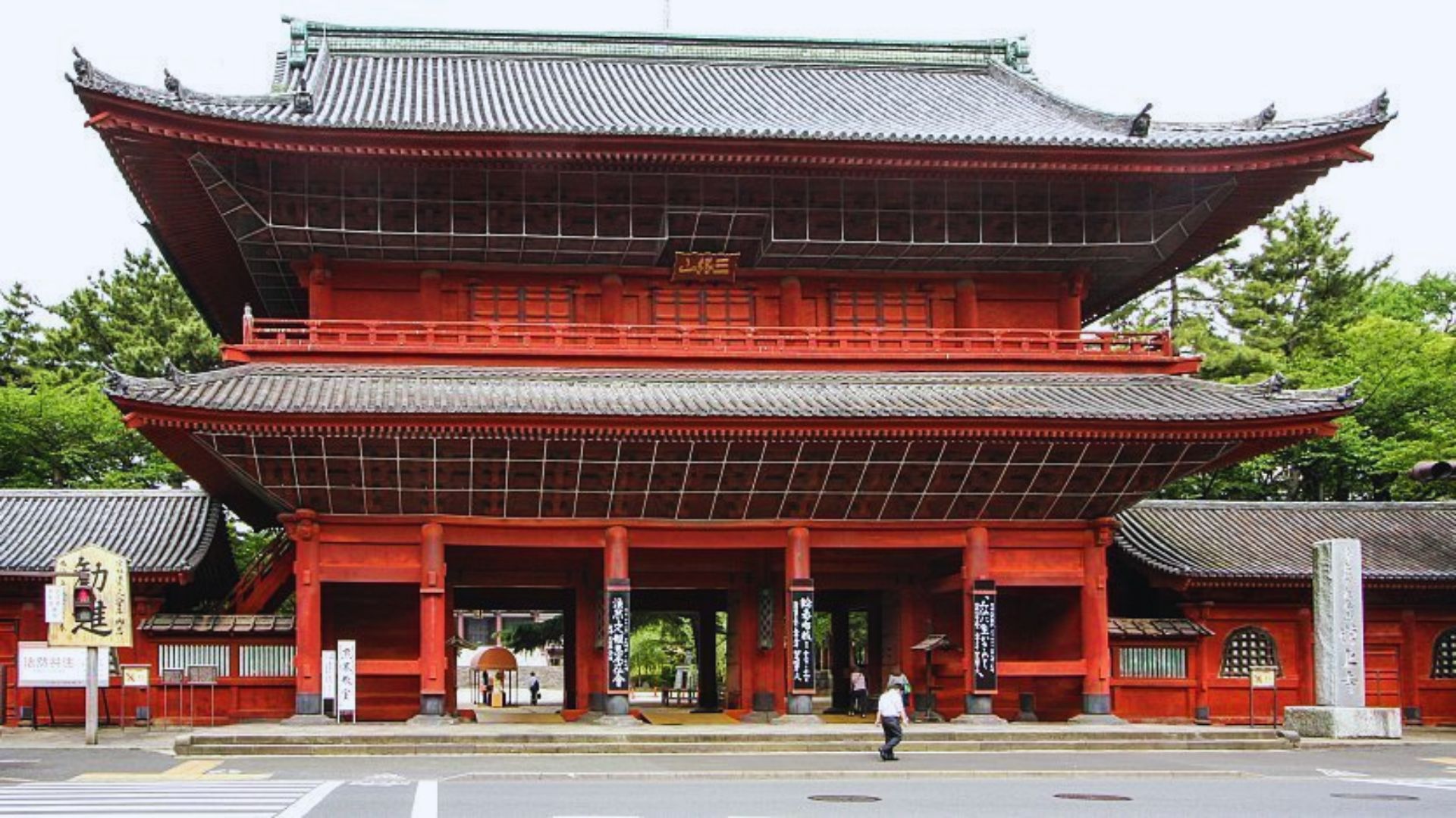 A red building with a large entrance gate, showcasing its impressive architecture.