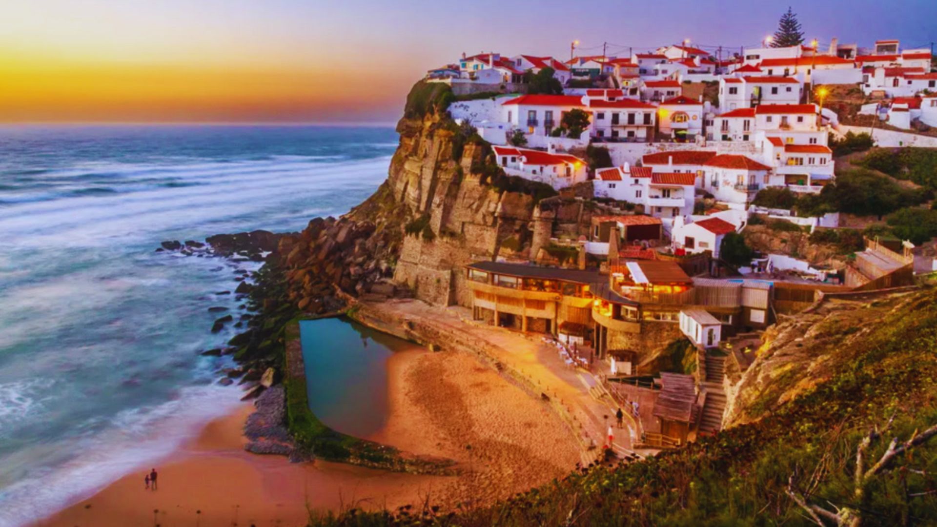 Sunset over the picturesque town of Algarve, Portugal, highlighting its charming architecture and vibrant sky colors.