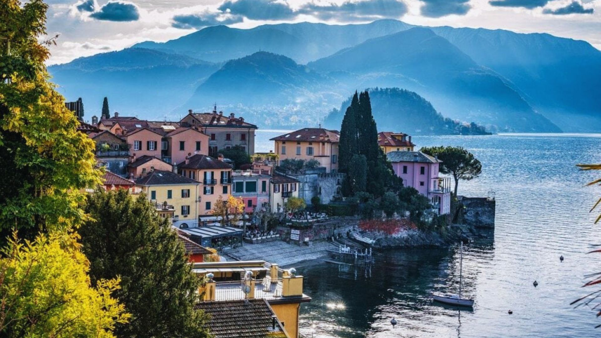 Scenic view of Lake Como, Italy, showcasing charming buildings and lush mountains surrounding the tranquil waters.
