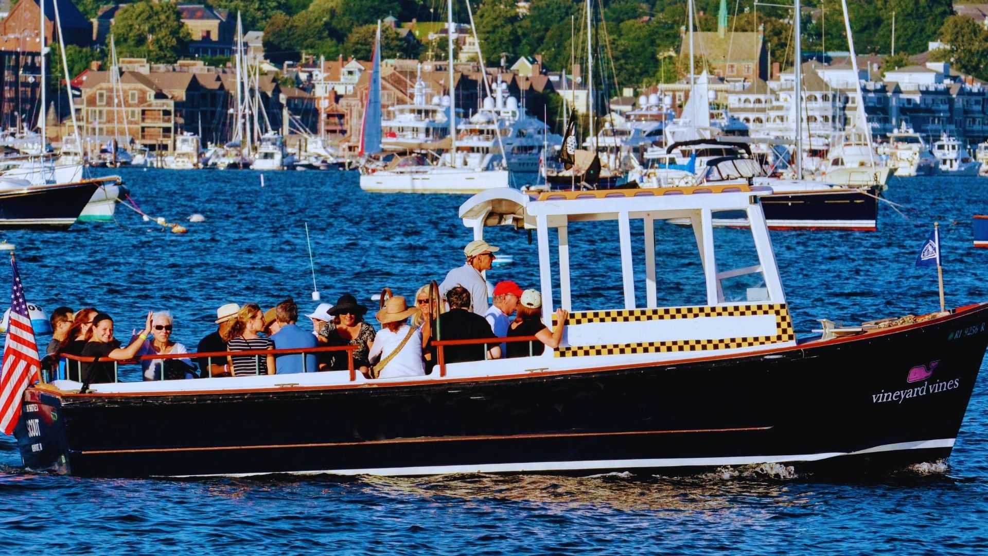 A boat with several people enjoying a day on the water, surrounded by gentle waves and a clear sky.