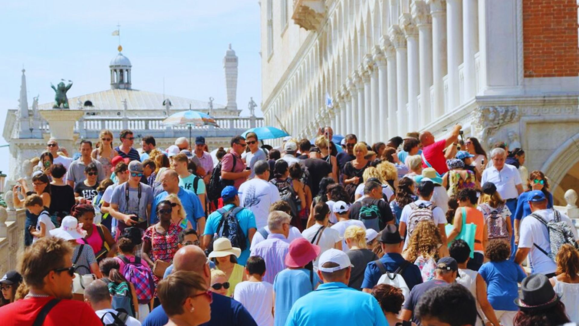 A diverse crowd of people ascending the stairs of a building, showcasing various ages and styles.