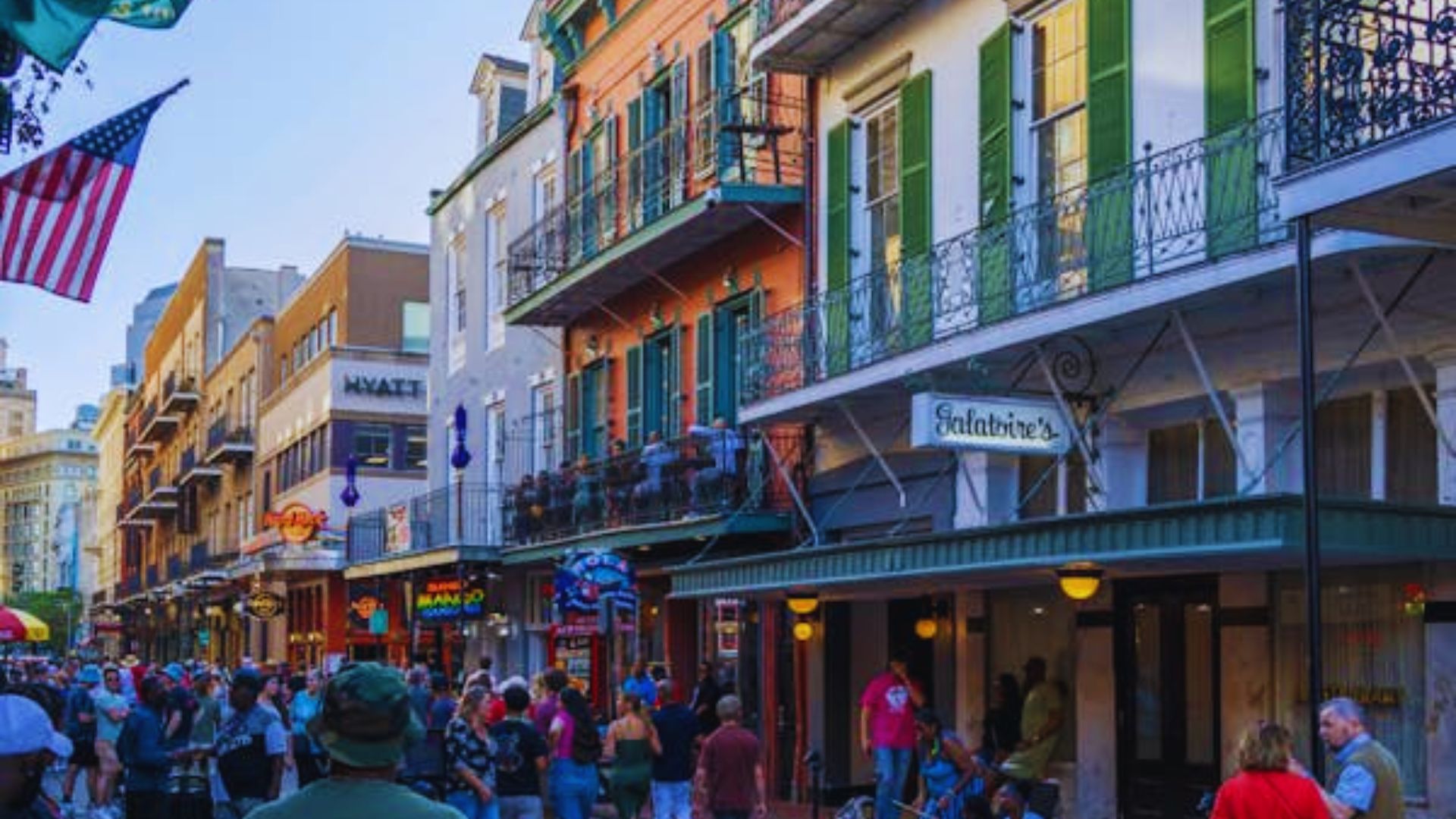 A bustling New Orleans street filled with people walking and enjoying the vibrant atmosphere of the city.