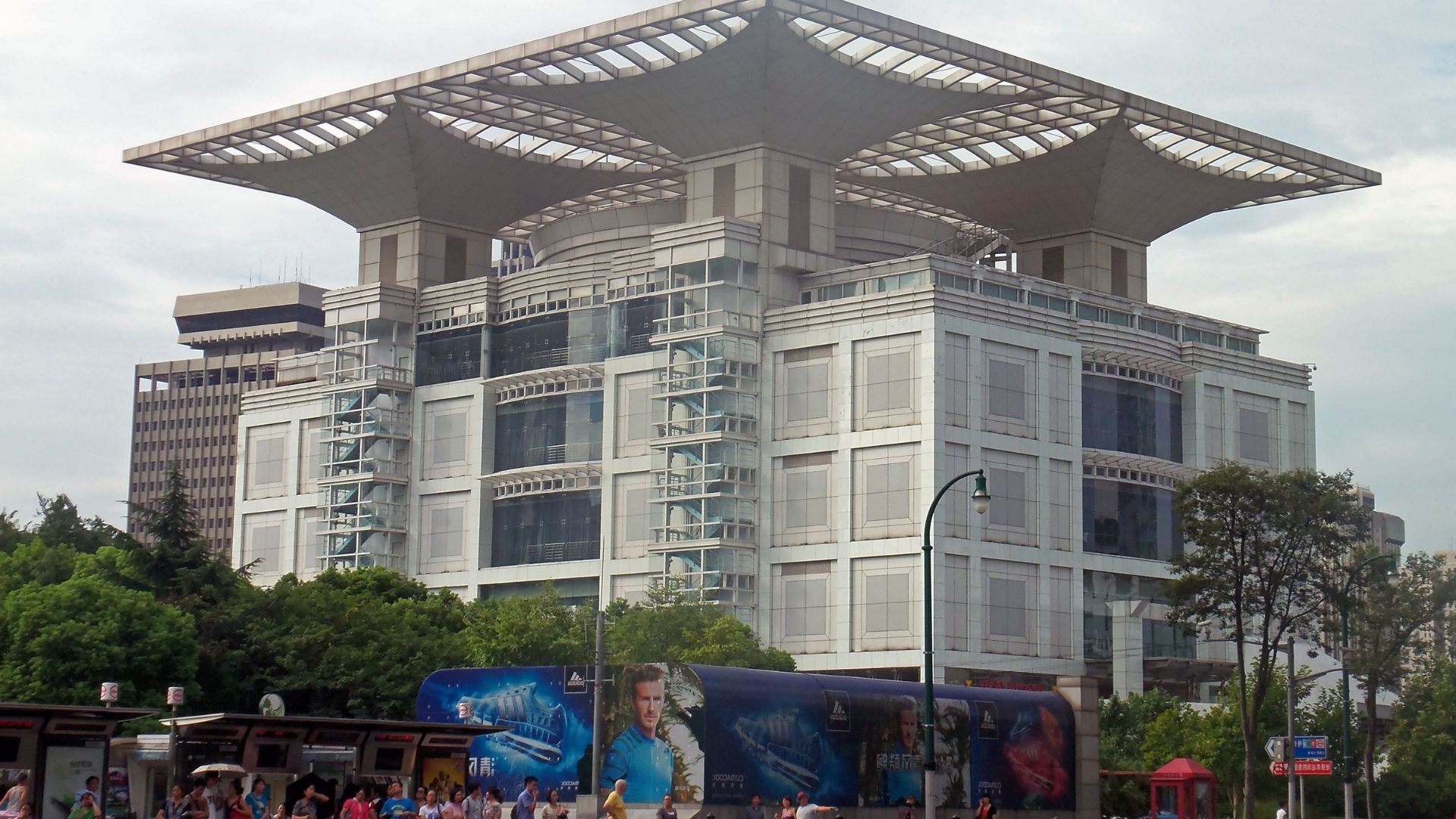A large building featuring a prominent white roof against a clear sky.