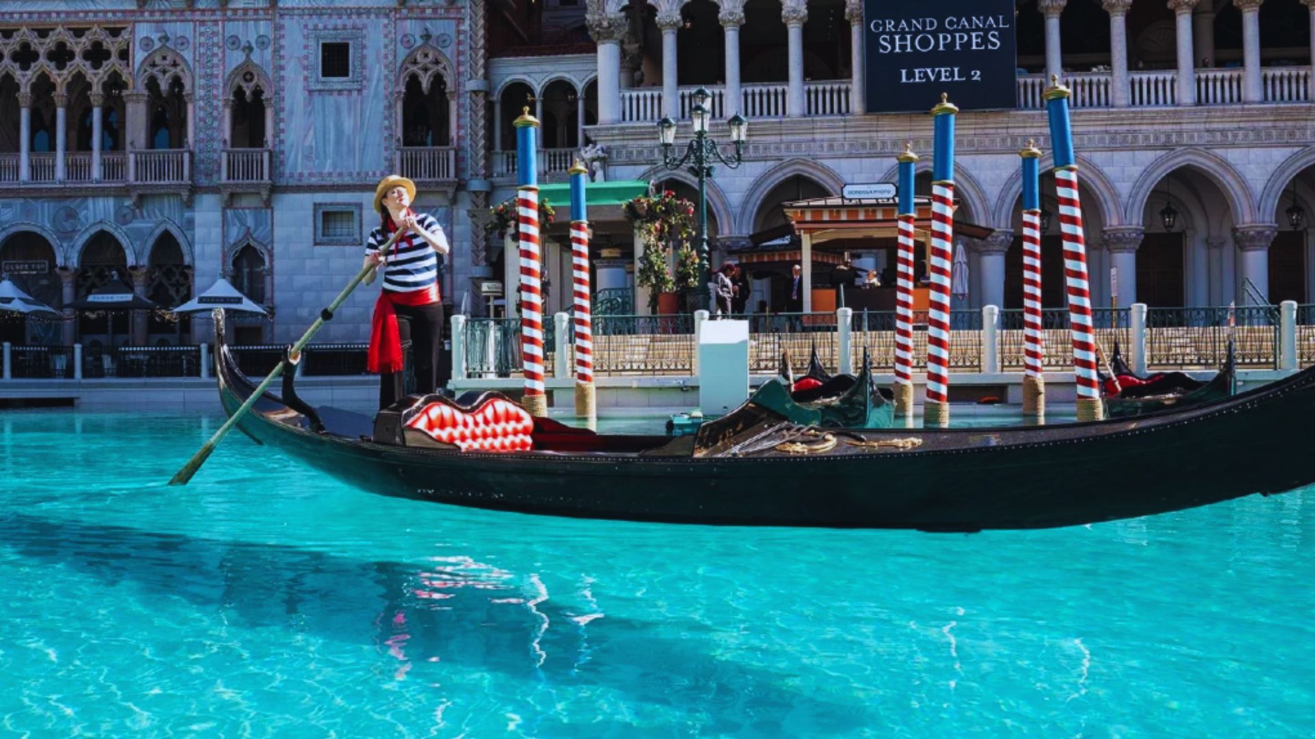 A gondola floats on the water beside a building, reflecting the serene atmosphere of the surrounding environment.