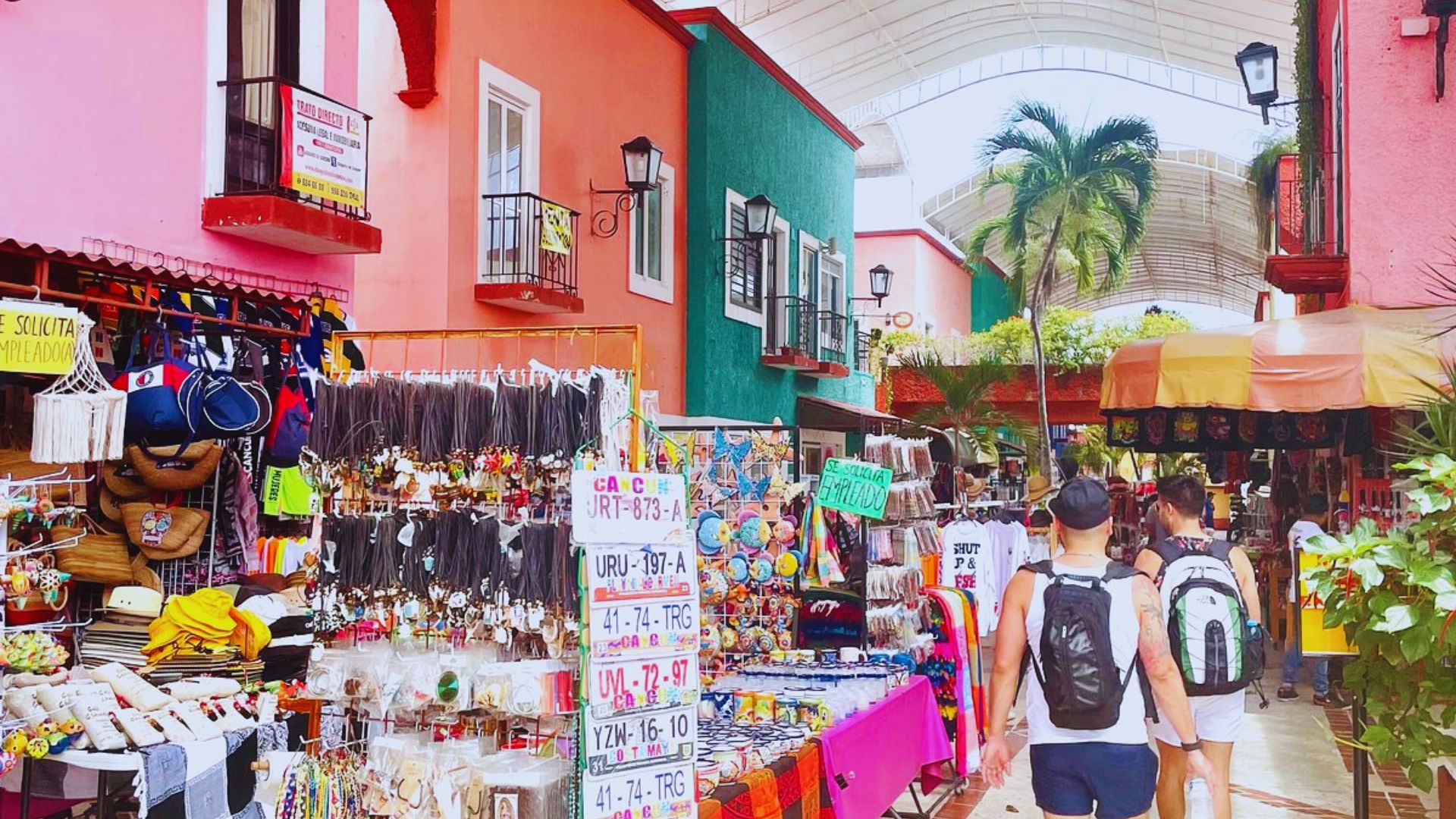 A vibrant market scene filled with people strolling among colorful stalls and goods.