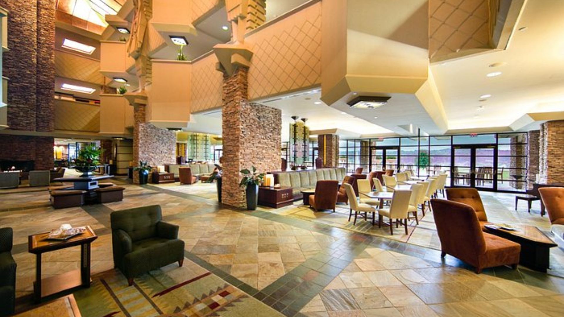 . Hotel lobby featuring a large, inviting fireplace surrounded by comfortable seating areas.