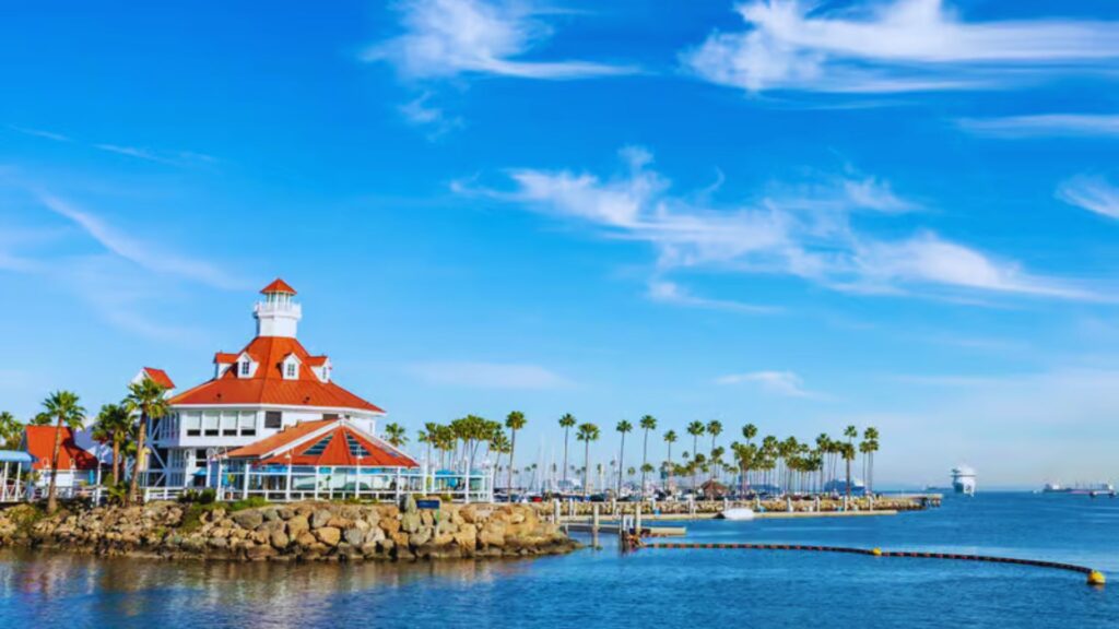 A scenic view of San Diego harbor, showcasing boats, waterfront buildings, and clear blue skies.
