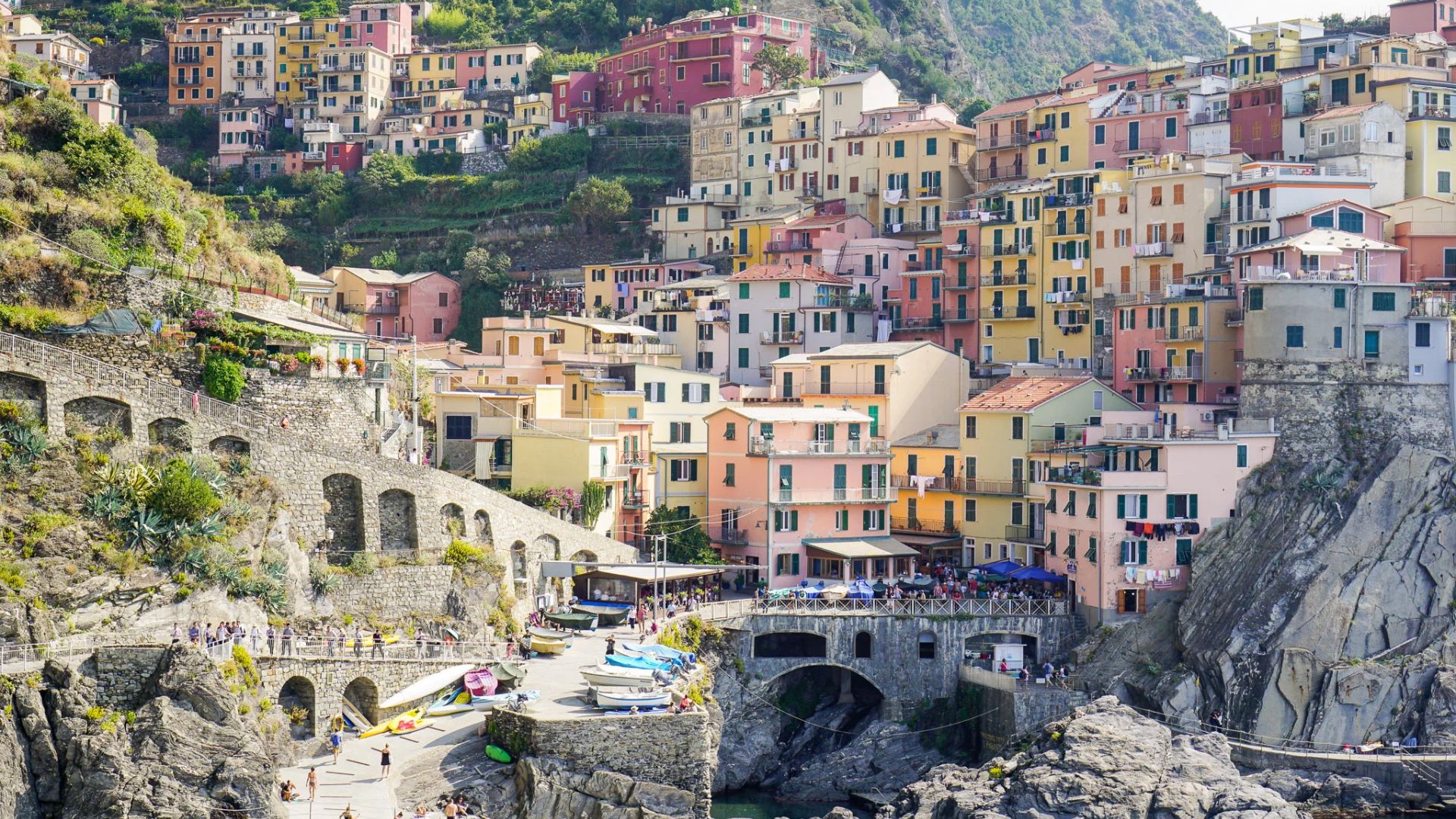 Vibrant houses line a cliffside, providing a stunning view of the ocean below.