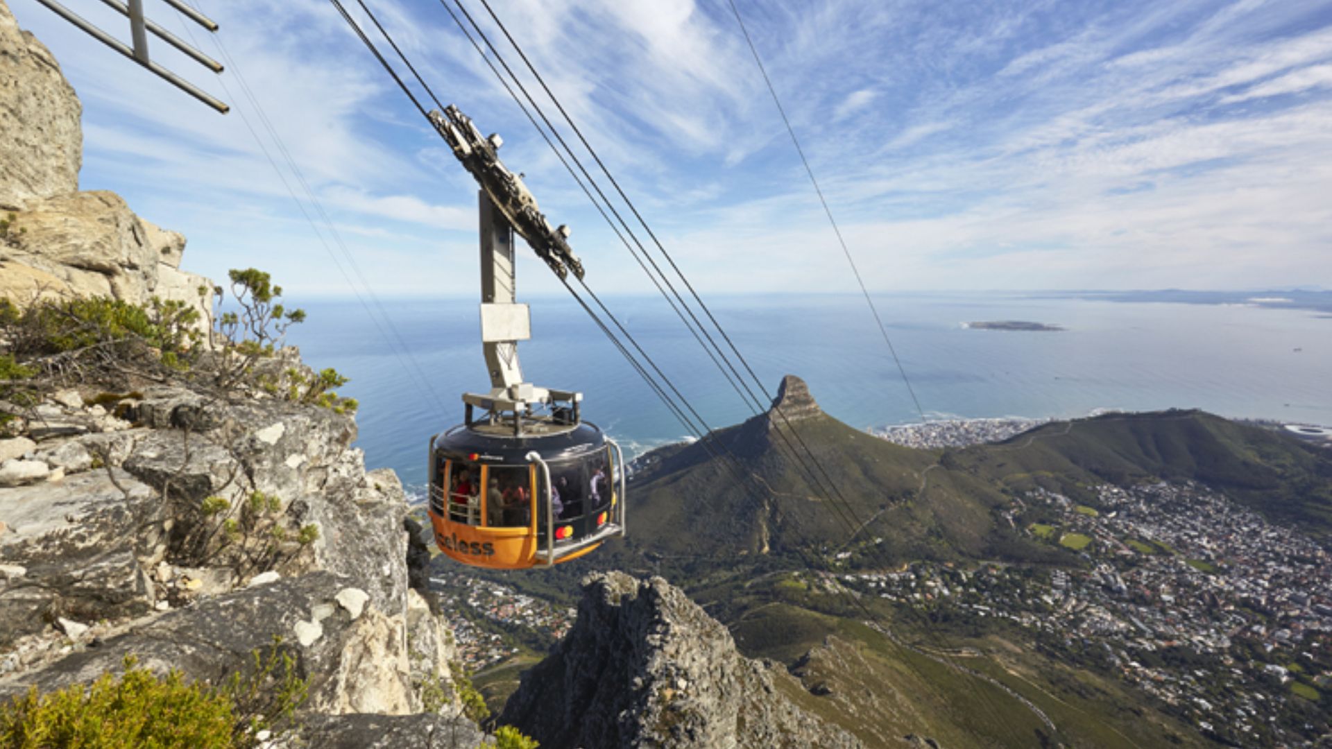 A scenic view of Table Mountain in Cape Town, featuring the cable car ascending the mountain against a clear blue sky.