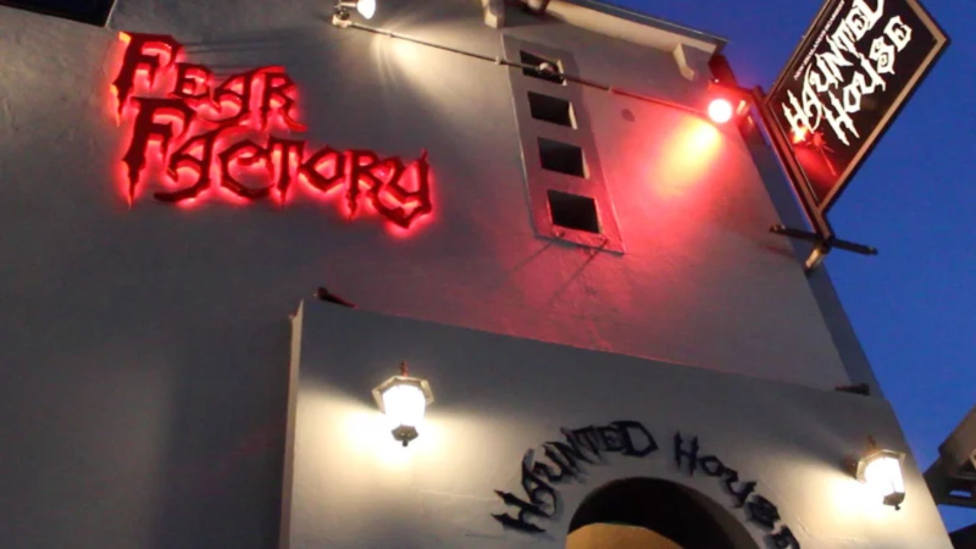 A building featuring a vibrant neon sign that reads "Flash Factory," illuminating the surrounding area at night.