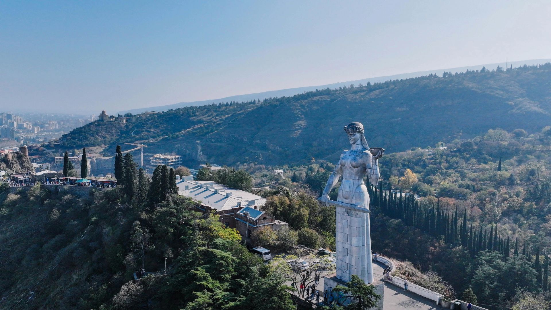 A statue of the Virgin Mary stands atop a hill, overlooking the surrounding landscape.